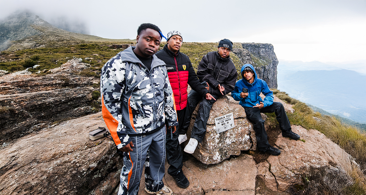 A crisp, clear photograph of a group of trendy young men on top of a mountain.
